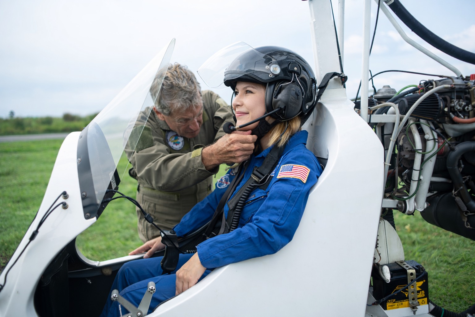 Pilot fitting a passenger's helmet before take-off